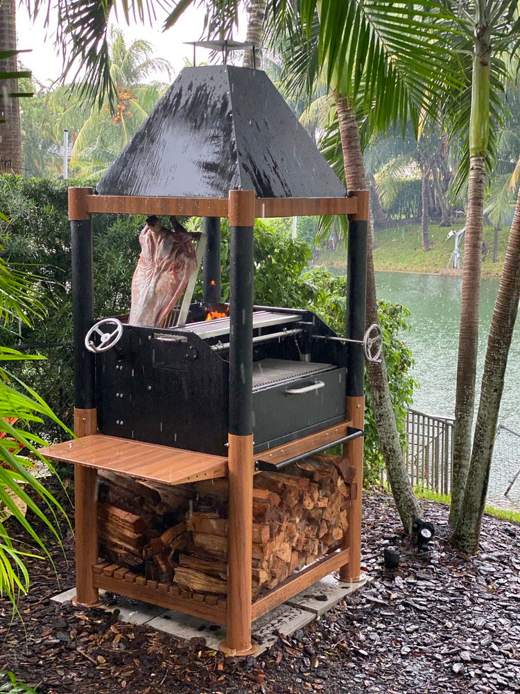 Argentine grill cooking meat next to palm tree and water 
