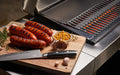 electric bbq with chopping board of sausages on it 